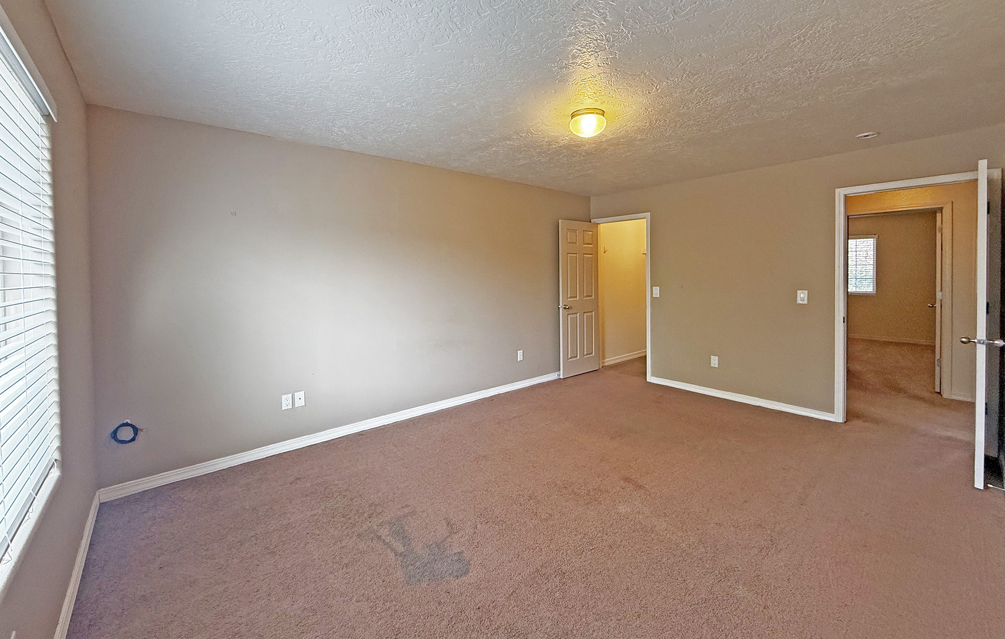 Master bedroom with doors to walk-in closet and hallway